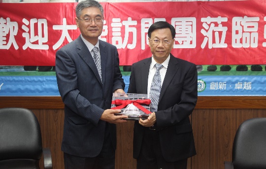 图说：北京北方工业大学校长王晓纯与亚大校长蔡进发互赠纪念品。